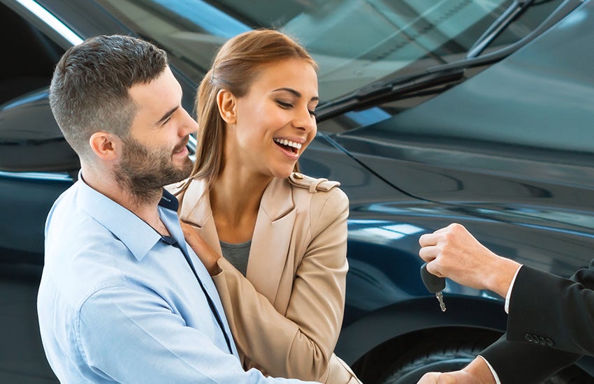 Salesperson handing couple keys